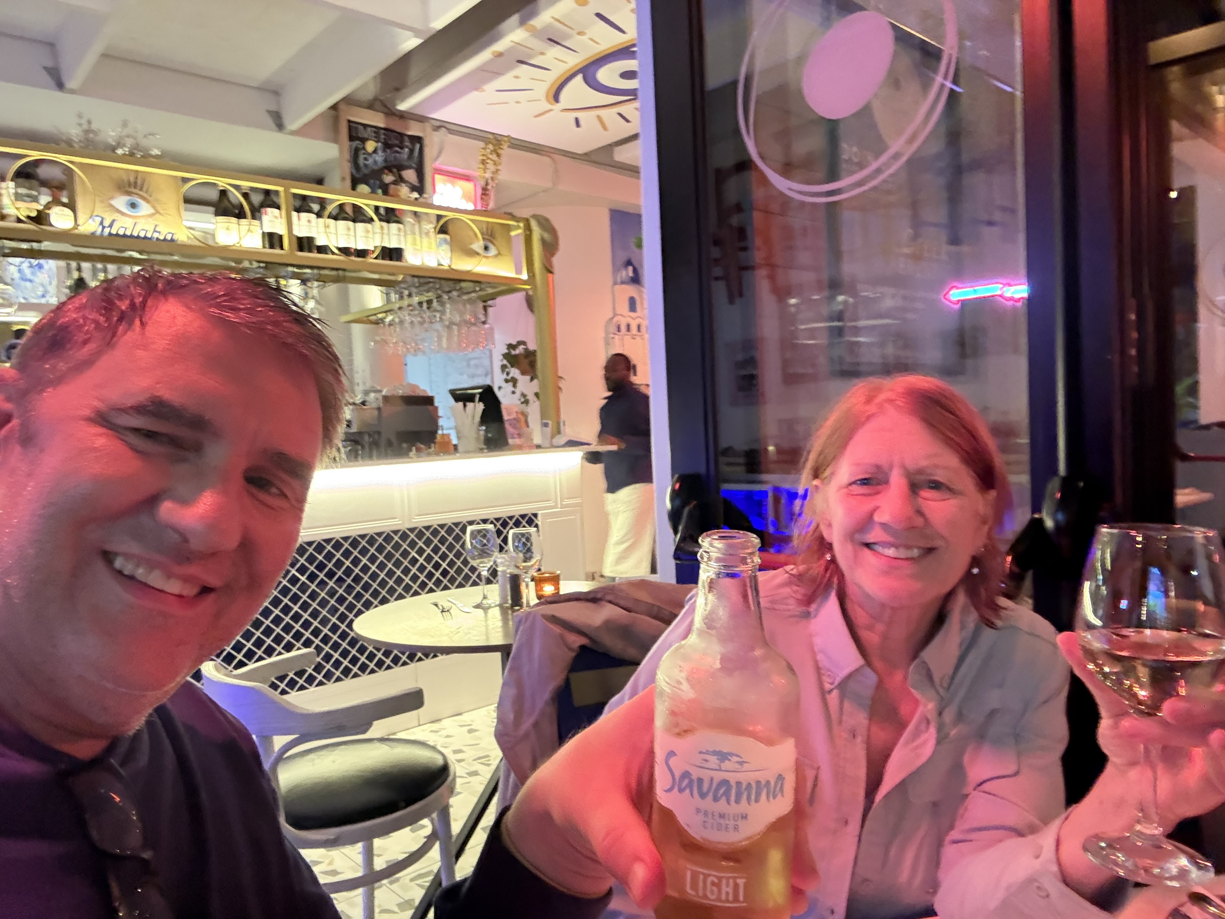 Mykonos Taverna, forty meters from the front gate. The first drink of the trip, and neither of us entirely awake.