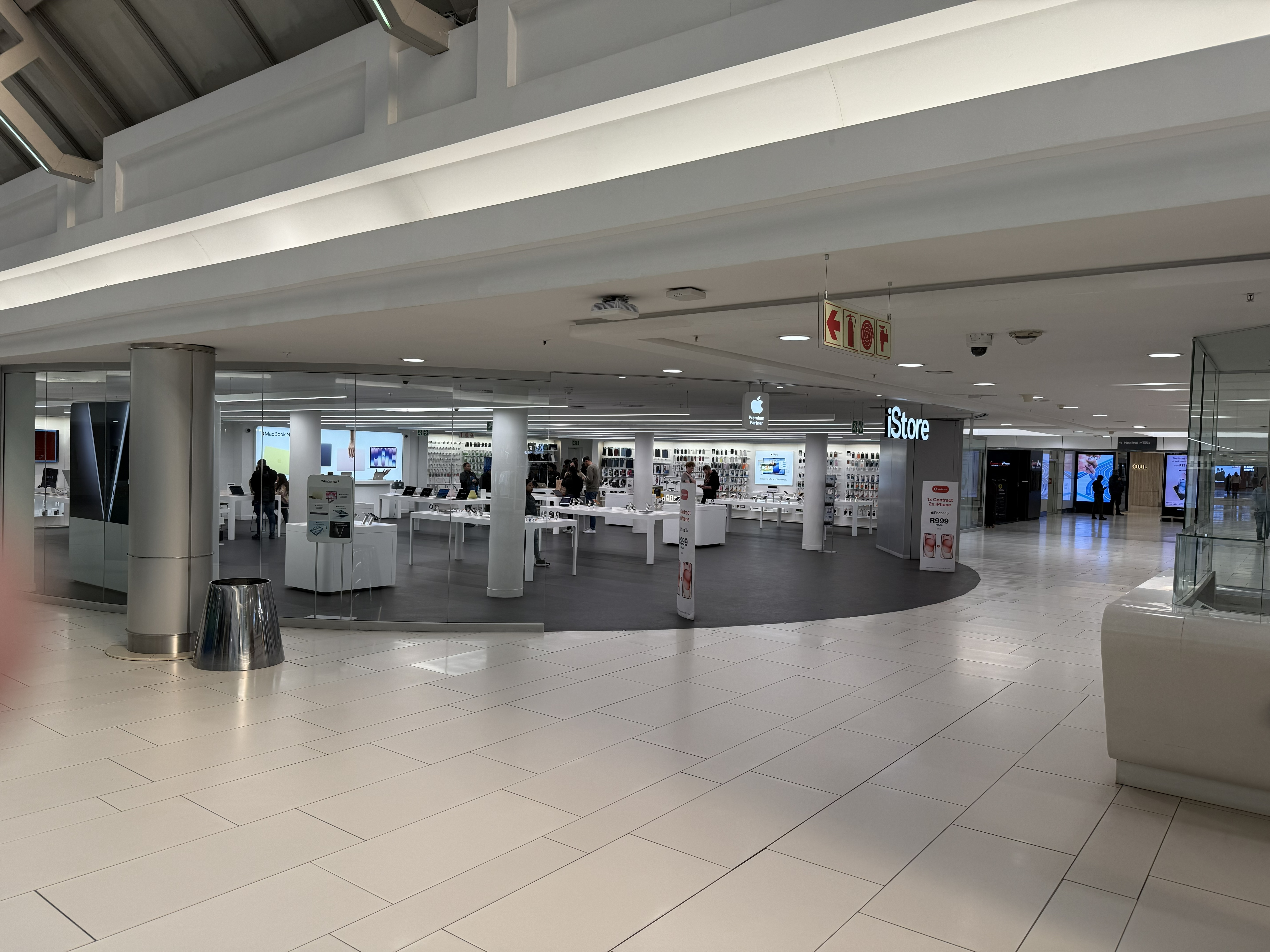 Sandton City. The iStore, which is an Apple Store, which looks exactly like every Apple Store you have ever stood in. The same white tables, the same lighting, the same hush. Nine