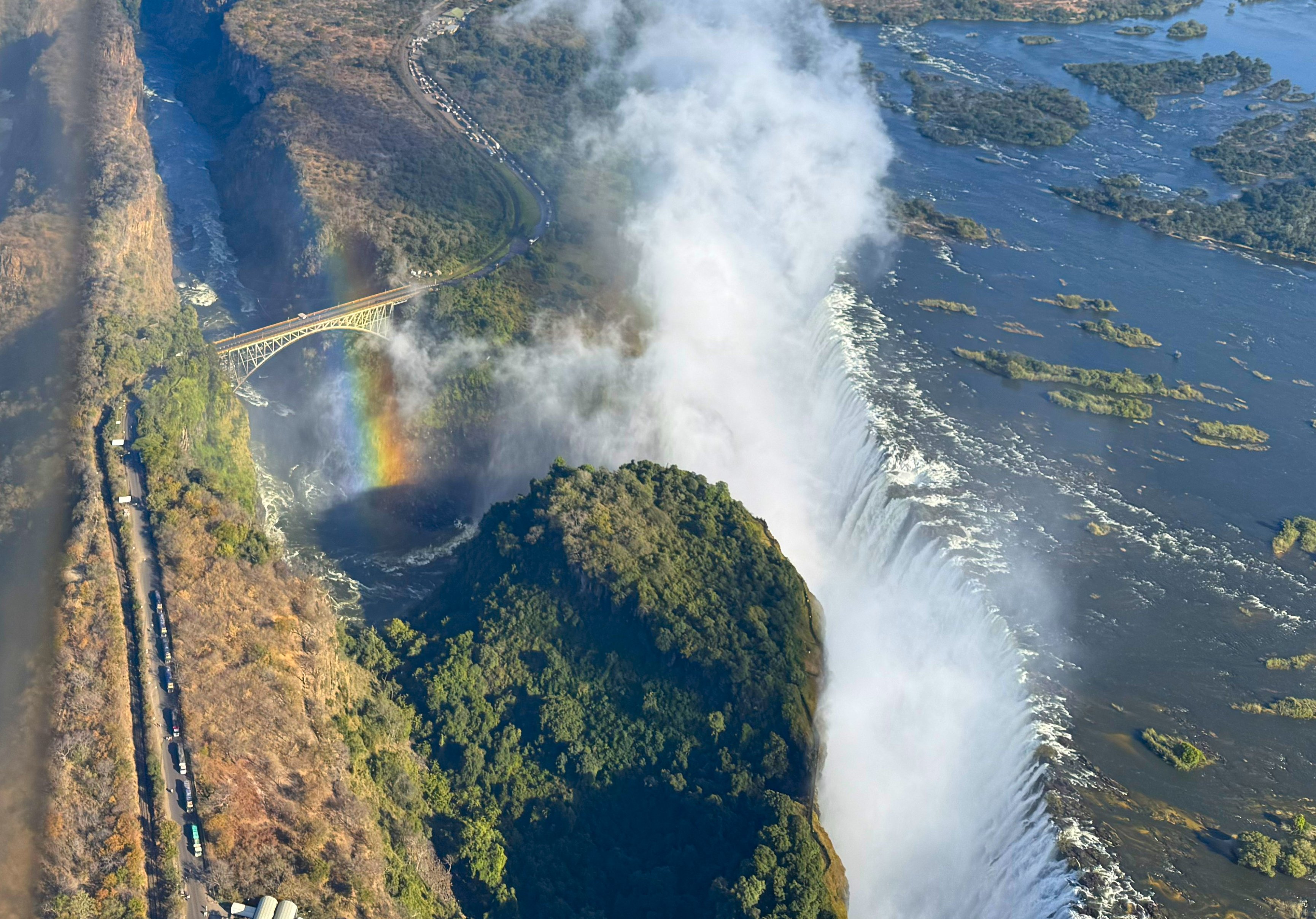 My photograph, from the helicopter. A rainbow lying across the gorge, seen from above, which is not an angle a person is built to have on a rainbow. This is the one I will keep.