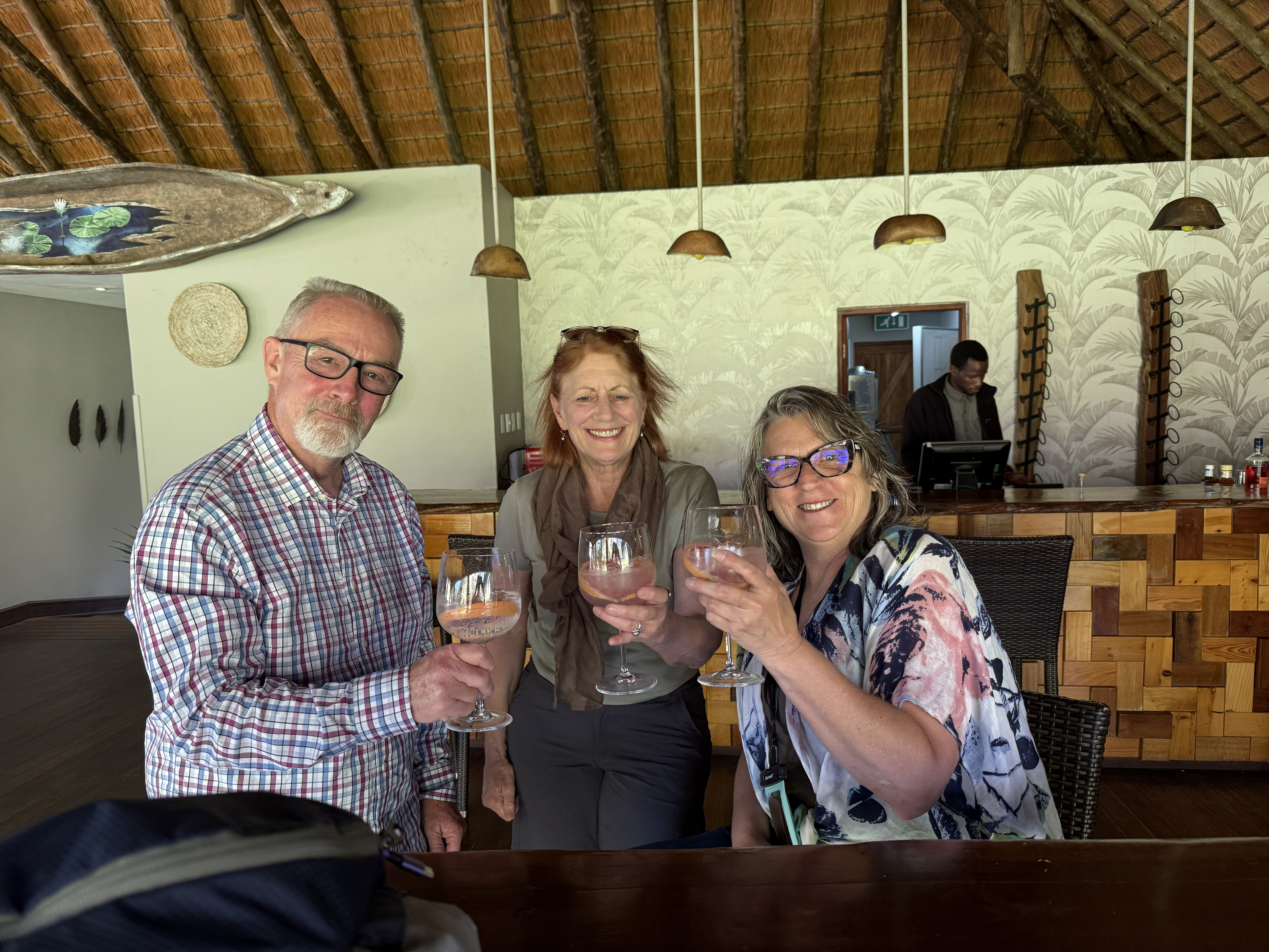 Bill, Bonnie, and Debbie, gin and tonics in hand — a drink with a genuine claim to this landscape, since the quinine that flavours the tonic was once taken, in earnest, against mal