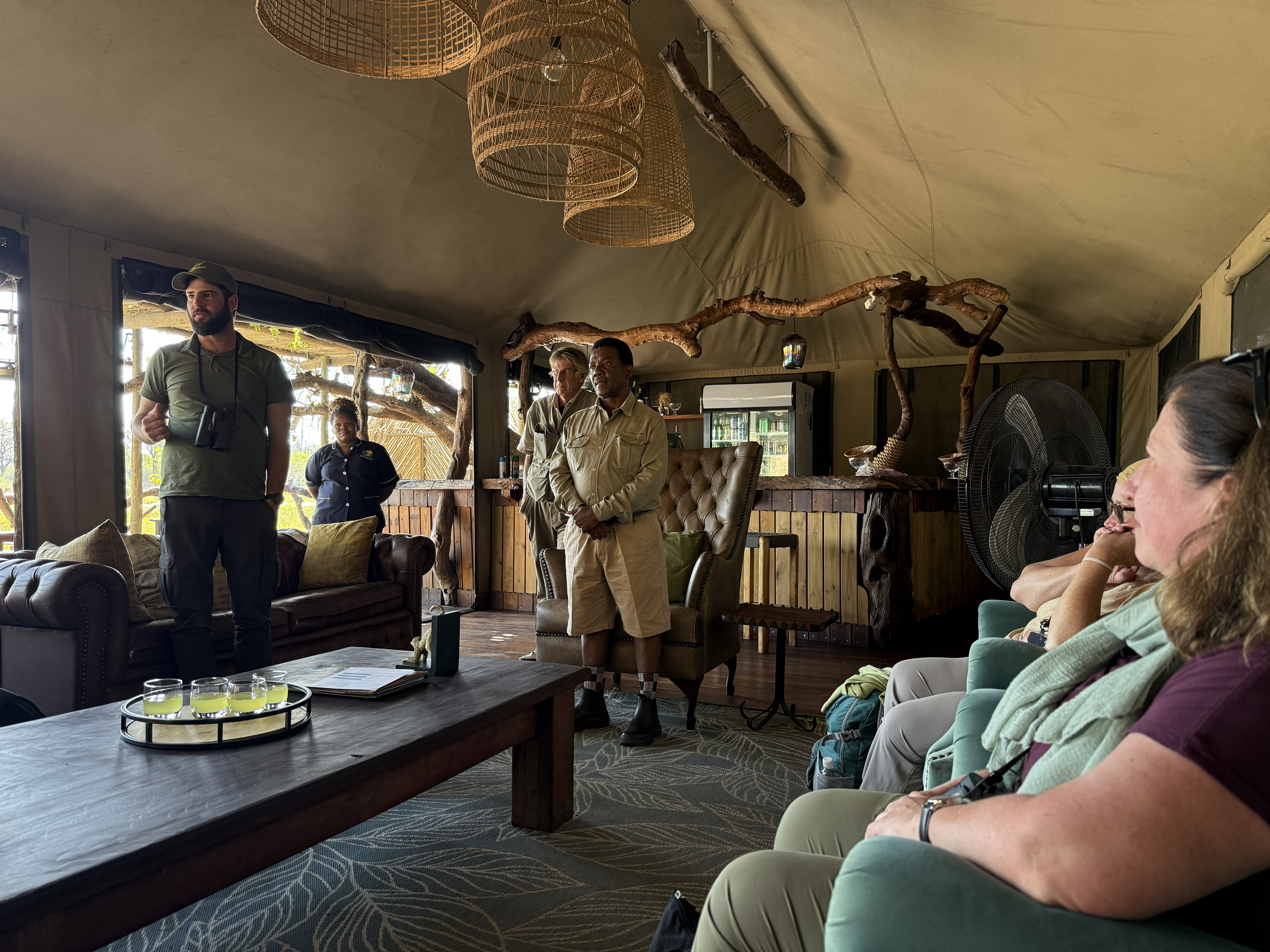 The welcome briefing in the lounge tent: Dylan (green cap) and the Saguni staff walking us through the Okavango and, more to the point, the rules after dark. You do not wander here