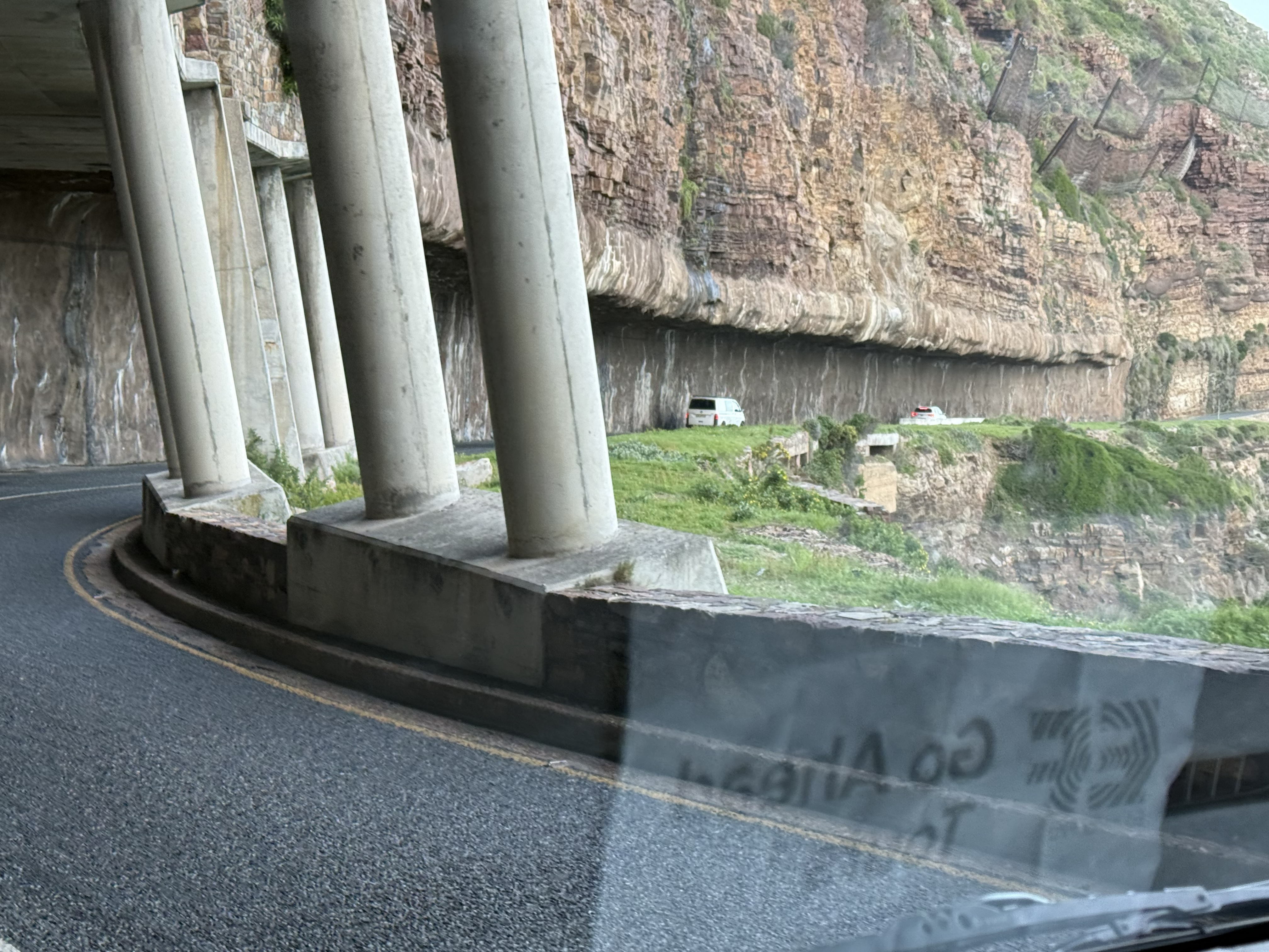 And the surprise: in places the road has a ceiling. These concrete canopies and the half-tunnel cut into the rock are there to catch what the cliff drops.